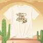Vanilla t-shirt with 'it's a Toy Story' text on a desert background with cacti.