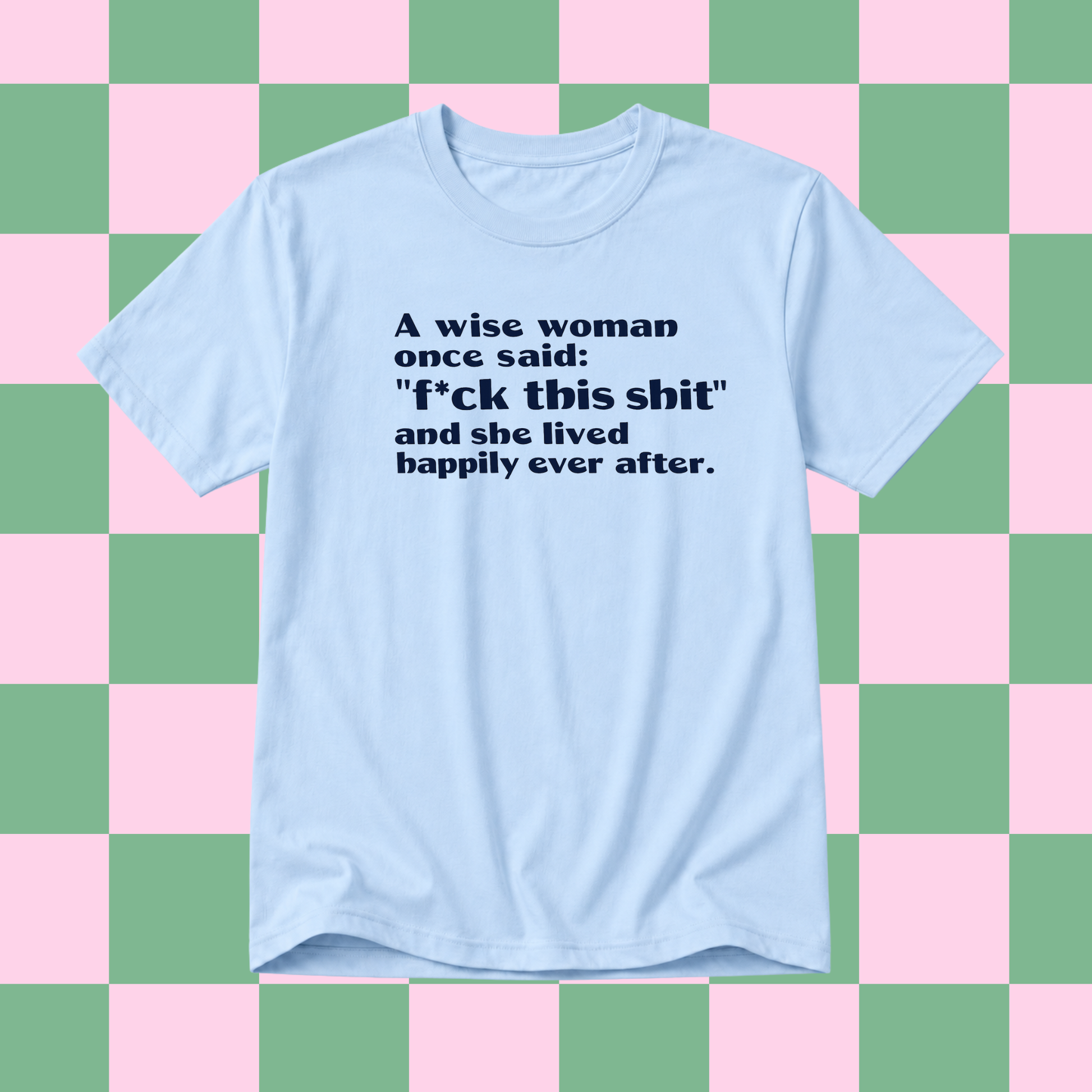 A light blue short-sleeve t-shirt with a dark navy text graphic on the front, displayed against a pink and green checkered background.