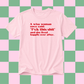A light pink short-sleeve t-shirt with red printed text on the front, displayed against a pink and green checkered background.