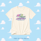 Beige t-shirt with 'Planet Swiftie' logo on a blue background with cloud patterns, featuring 'The Paper Press'.