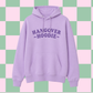 A light purple/lavender pullover hoodie with the words 'HANGOVER HOODIE' printed in dark purple across the chest, shown against a pastel pink and mint green checkered background.