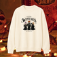 An off-white crewneck sweatshirt featuring a 'Salem Witches' graphic print with three witch characters and gothic text, displayed against a warm, spooky Halloween-themed background with the brand name 'THE PAPER PRESS' at the bottom.